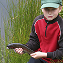 Boy with fish during his Junior Outdoorsman outing.