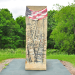 Piece of the Berlin Wall with an American flag banner draped over top.